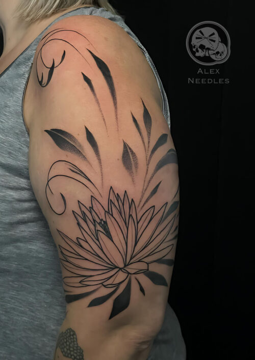 Tatouage floral abstrait sur le haut du bras, réalisé par Alex Needles à Boulogne-sur-Mer