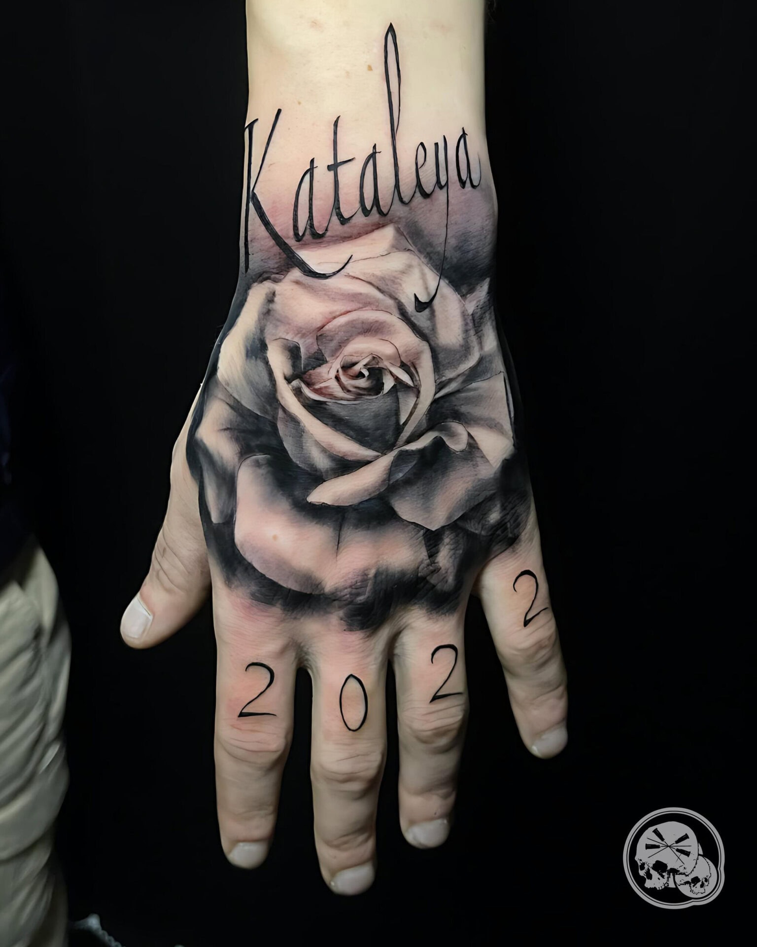 Tatouage rose avec date et lettrage sur la main à Boulogne-sur-Mer (62) - The Needles Factory