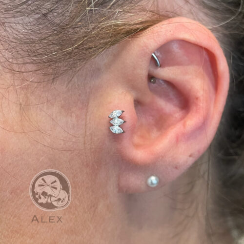 Oreille percée avec un bijoux au trapus avec 3 strass sur un labrit en titane pas de vis interne
