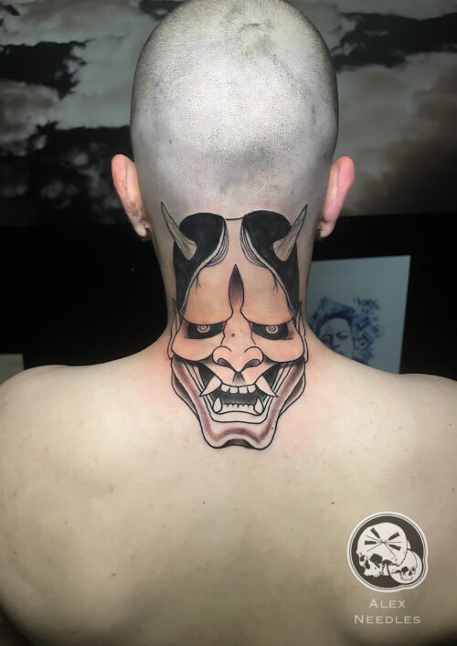 Tatouage d'un masque d'Oni en noir réalisé sur une nuque par Alex, The Needles Factory