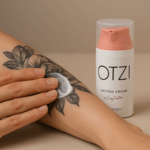 Application de la crème Otzi Tattoo Cream sur un tatouage floral en noir et gris pour favoriser la cicatrisation et l’hydratation après tattoo – The Needles Factory Boulogne