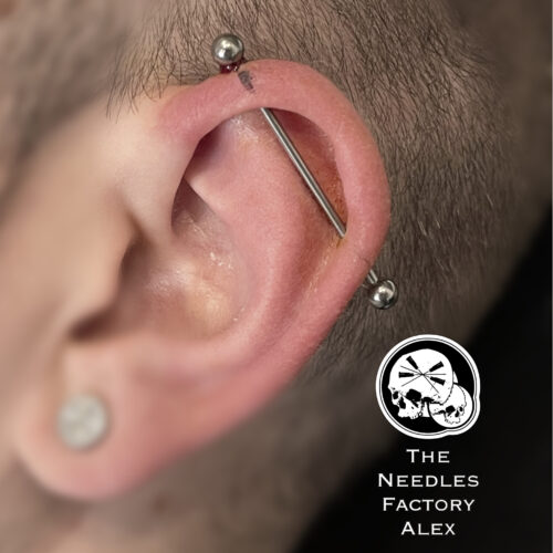 Piercing industriel à l’oreille avec bijou en titane, réalisé par Alex The Needles Factory.
