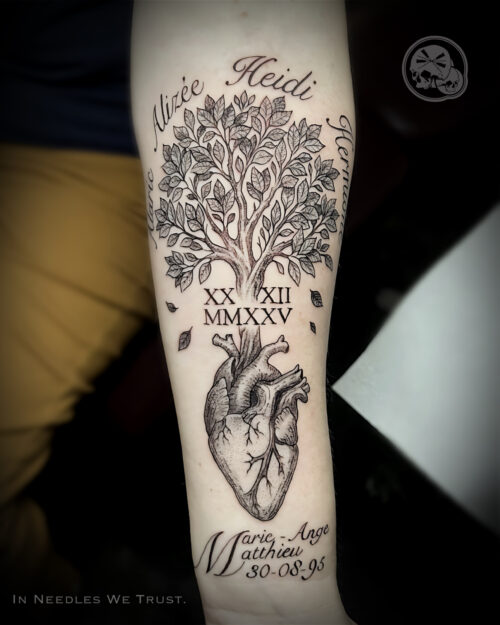 Tatouage arbre de vie avec cœur anatomique en noir & gris sur avant-bras, prénoms calligraphiés — The Needles Factory, Boulogne-sur-Mer