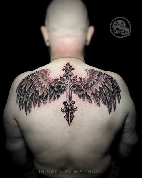 Tatouage croix avec ailes d’ange – grand dos – The Needles Factory Boulogne-sur-Mer Tatouage croix avec ailes d’ange sur le haut du dos à Boulogne-sur-Mer