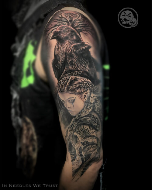 Tatouage Valkyrie réaliste en noir & gris sur bras avec corbeaux (Huginn & Muninn) et Yggdrasil — The Needles Factory, Boulogne-sur-Mer