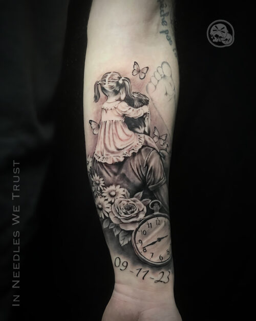 Tatouage réaliste noir et gris : portrait homme & enfant, fleurs et montre – Boulogne-sur-Mer (62) | The Needles Factory Tatouage réaliste noir et gris d’un homme et d’une petite fille sur l’avant-bras, Boulogne-sur-Mer (62)