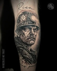 Tatouage hommage mineur réaliste noir et gris sur mollet à Boulogne-sur-Mer (62)