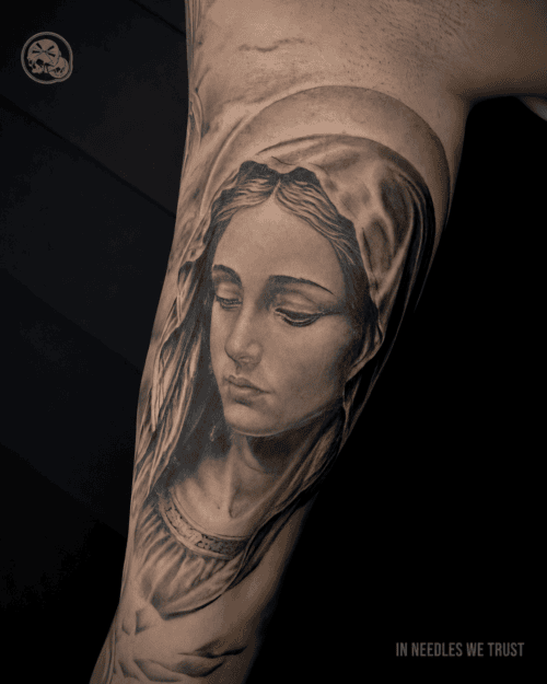 Tatouage réaliste de la Vierge Marie à Boulogne-sur-Mer (62) – The Needles Factory Tatouage réaliste de la Vierge Marie en noir et gris sur le bras à Boulogne-sur-Mer (62)