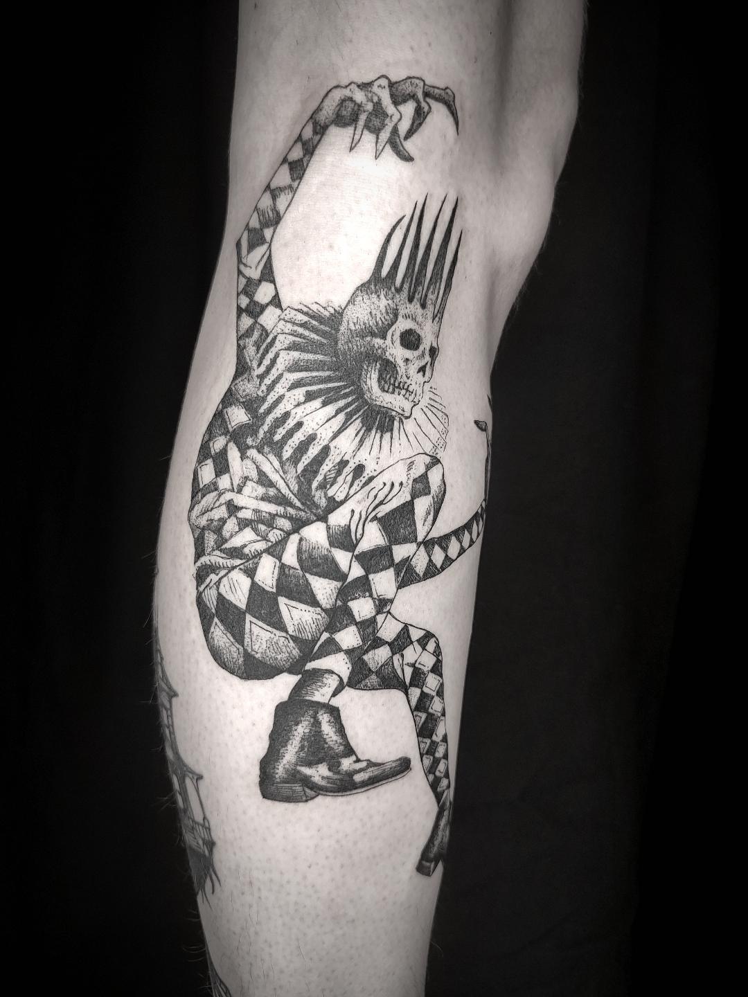 Tatouage arlequin et squelette sur le mollet