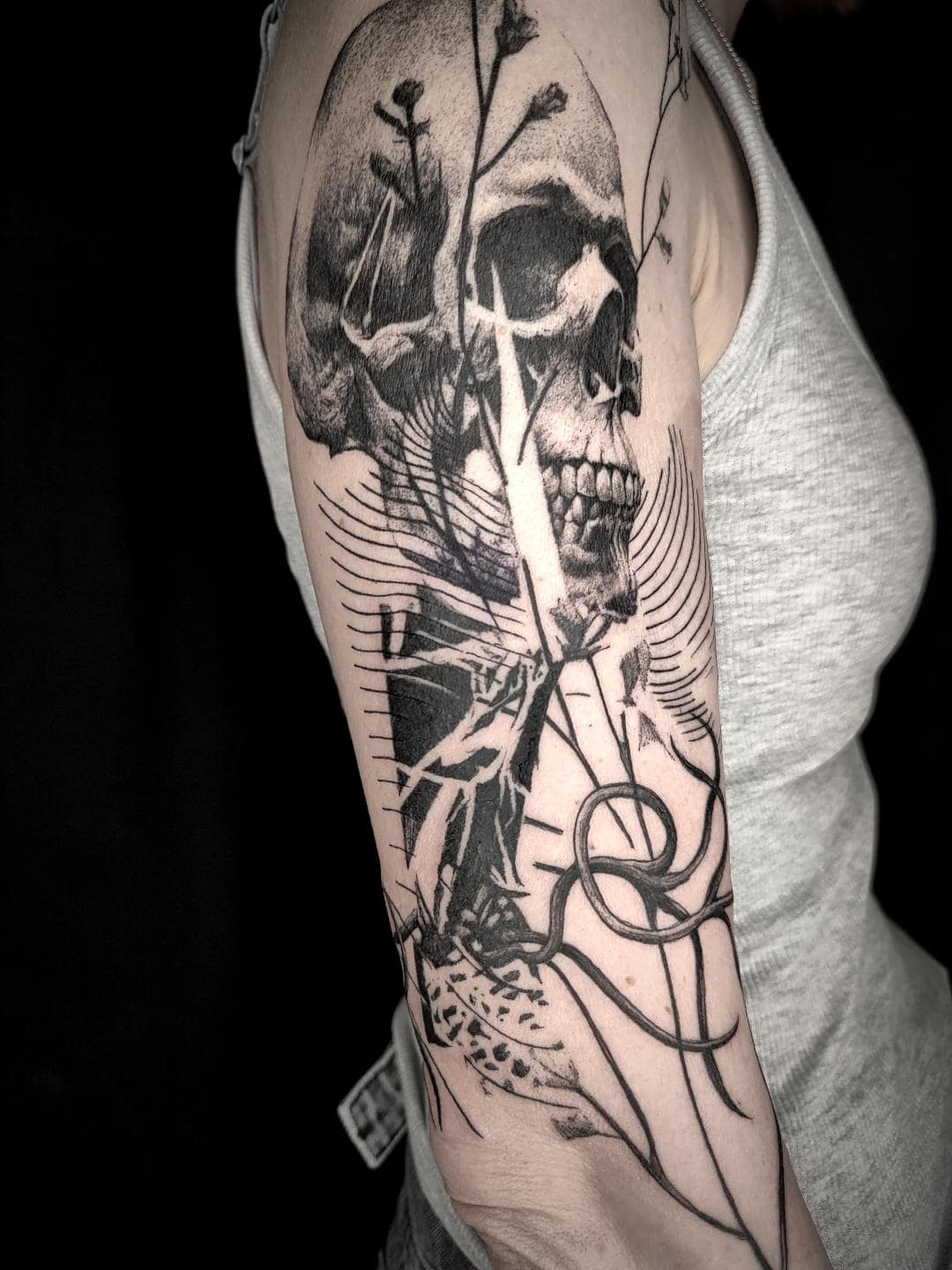 Tatouage de crâne en collage graphique sur le bras