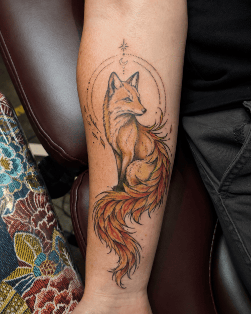 Tatouage renard à queue de phénix en couleur sur l’avant-bras